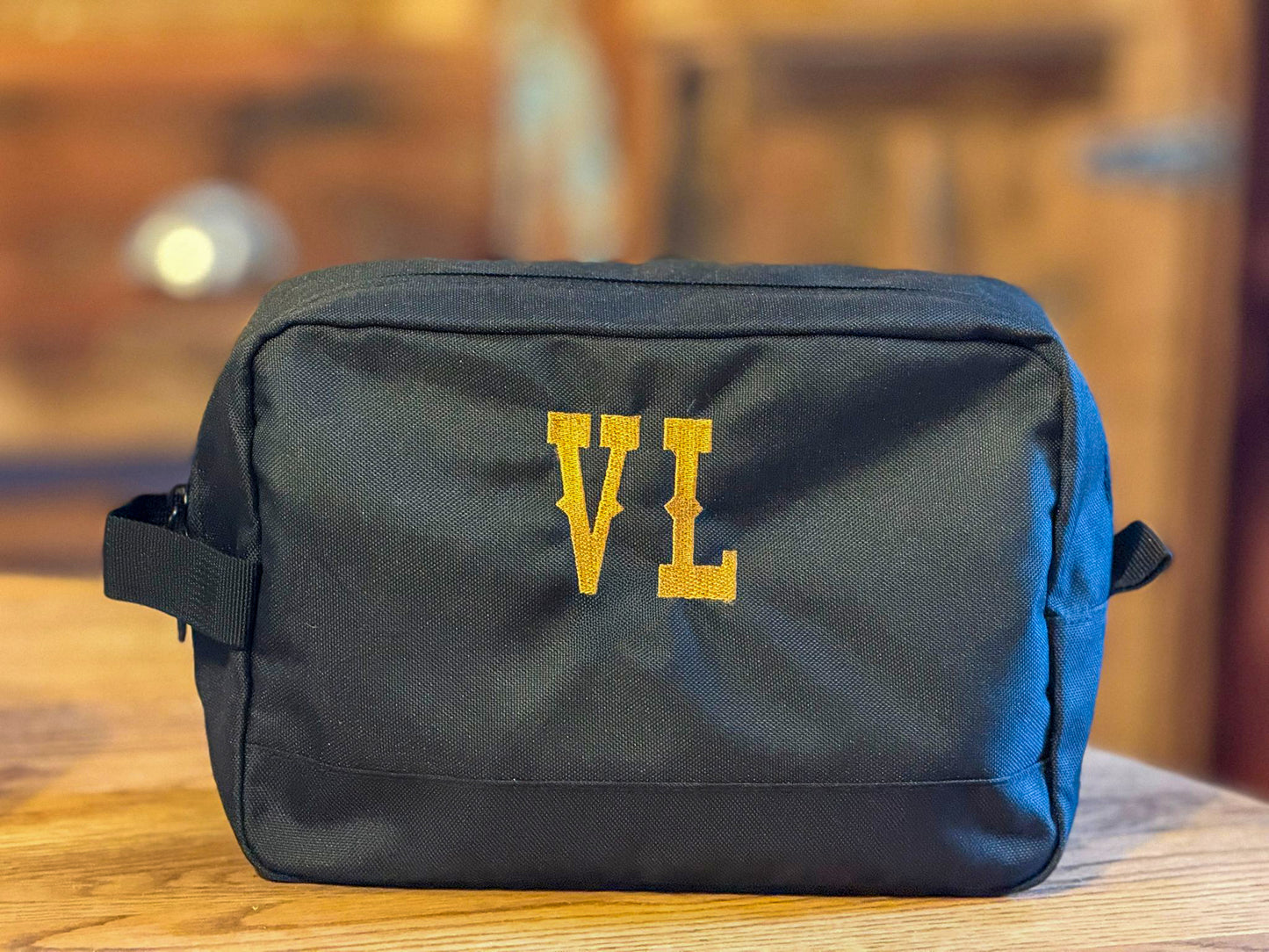 Personalisierter Kulturbeutel / Kosmetiktasche aus recyceltem Polyester in Grau, beidseitig bestickt mit Western-Motiv und Initialen.