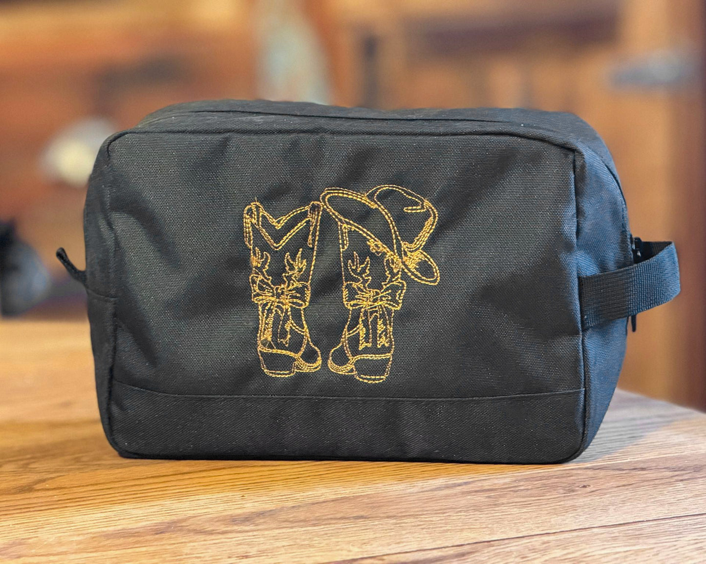 Personalisierter Kulturbeutel / Kosmetiktasche aus recyceltem Polyester in Grau, beidseitig bestickt mit Western-Motiv und Initialen.