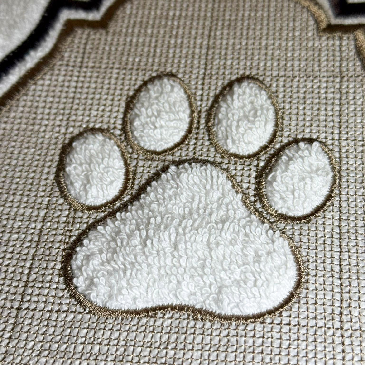 Pfotenmotiv Stickerei Detail auf Badetuch, hochwertige Prägung Baumwolle