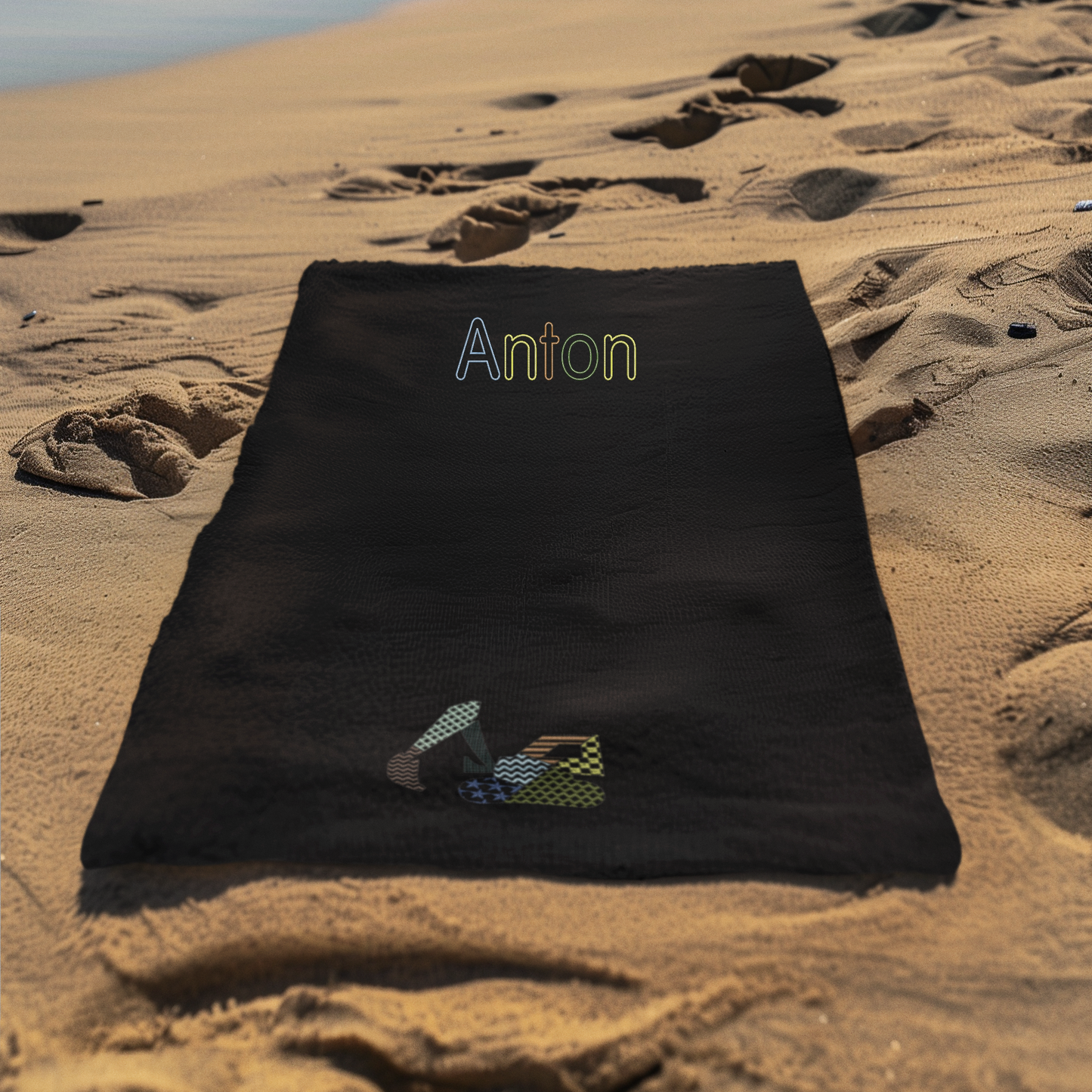 Personalisierter Name und gestickter Patchwork-Bagger auf Badetuch, farblich angepasst