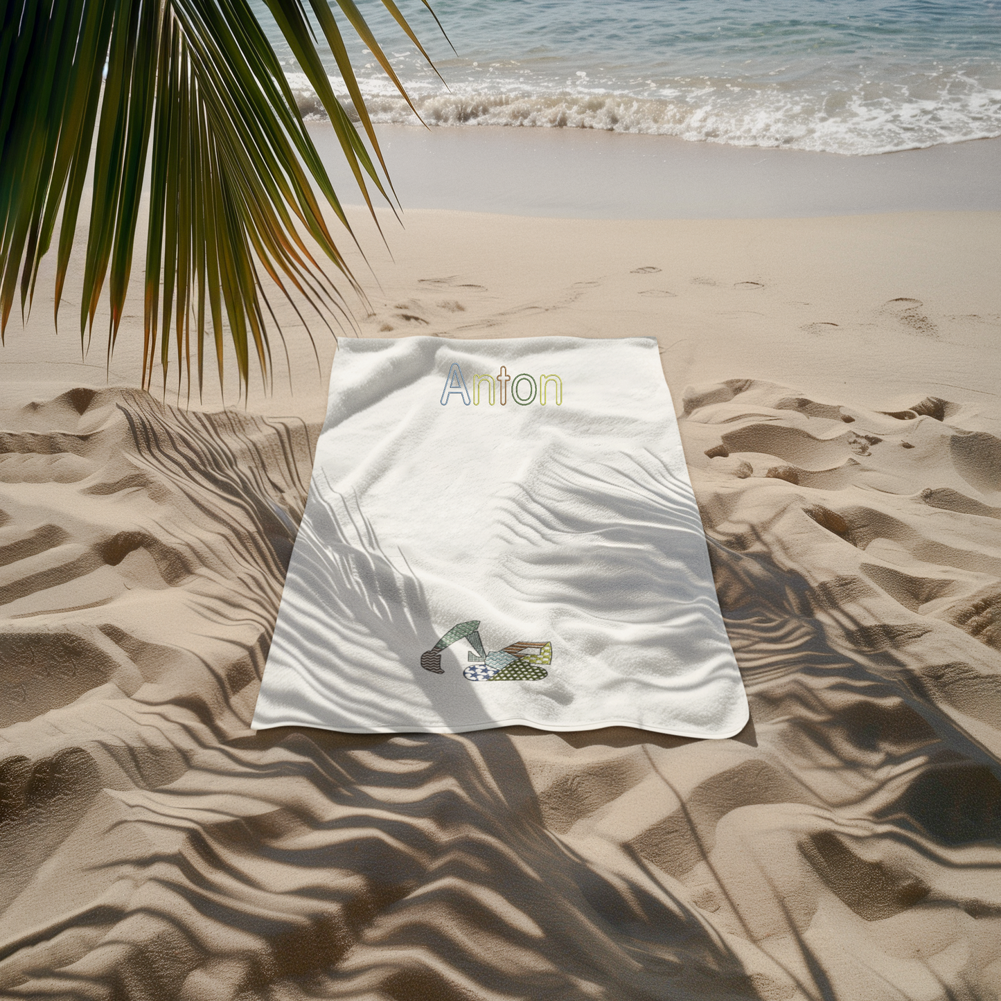 Personalisierter Name und gestickter Patchwork-Bagger auf Badetuch, farblich angepasst