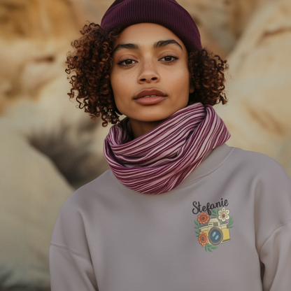 Frau trägt ein lila Sweatshirt mit besticktem Kamera- und Blumenmotiv sowie personalisiertem Namen Stefanie.