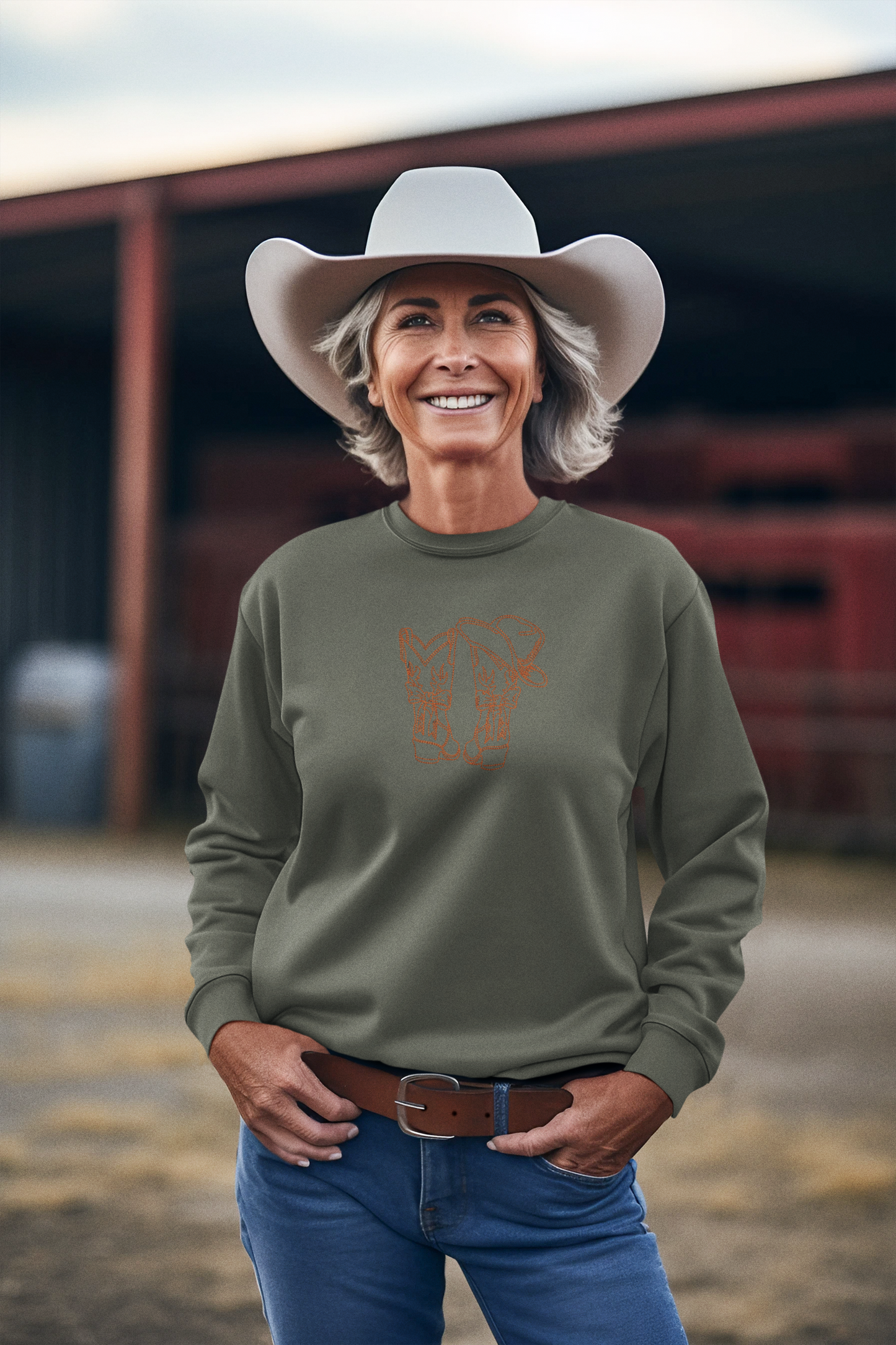 Frau trägt lila Sweatshirt mit brauner Stickerei von Cowboy-Stiefeln und Hut
